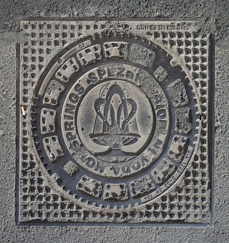 Manhole cover in Karlovy Vary. This is the trademark of a Hot Springs Company. HOT SPRINGS SPLZaK VŘÍDELNÍ VODA.
