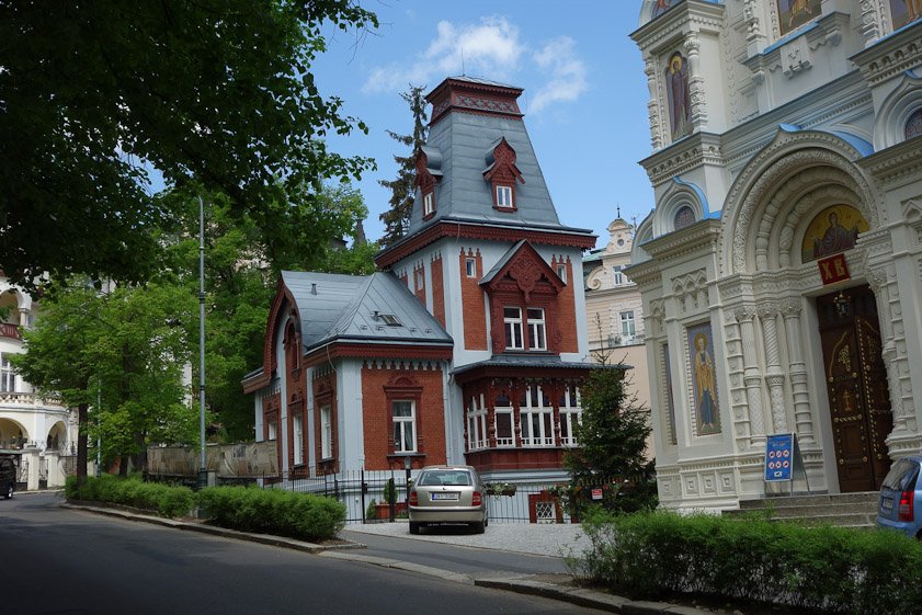 The west door of St. Peter and Paul and a red building next door.