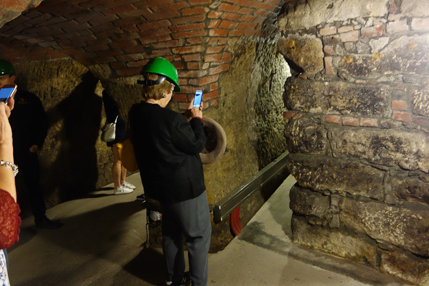 The tourists wore green hard hats; the guide a red hat.