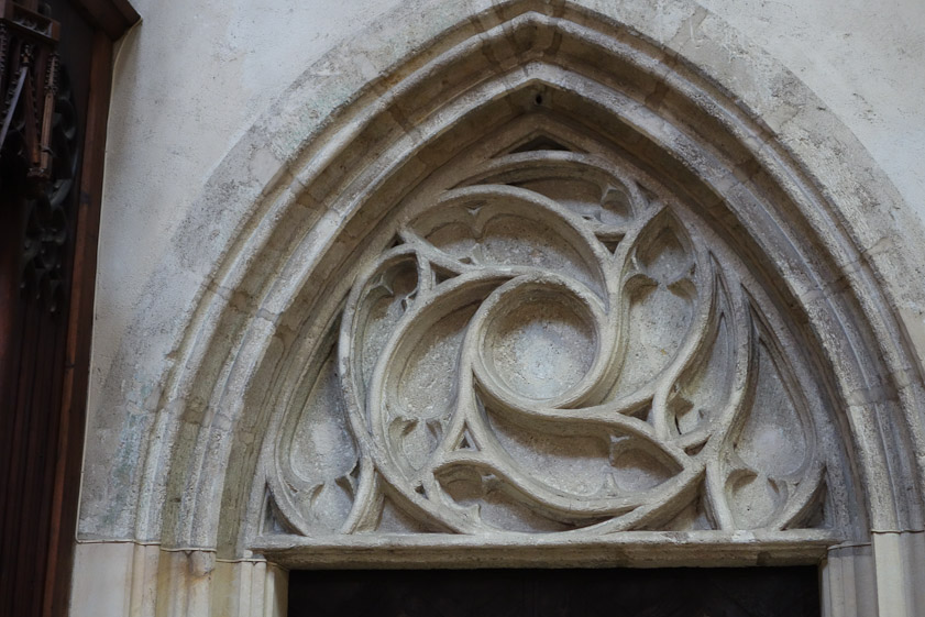 Tracery above a doorway at the west end of the north aisle.