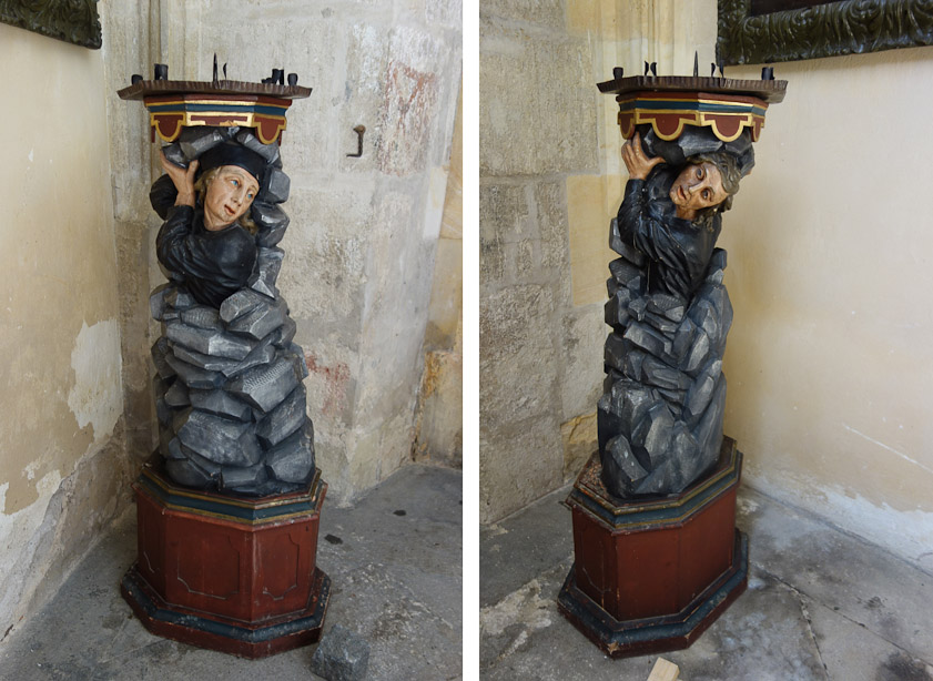 A pair of candlesticks flanking a door in the south aisle, with figures seeming to emerge from rock (silver ore?).