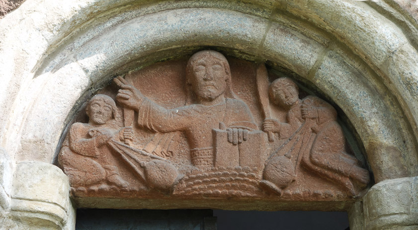 The tympanum over the south door to Sv. Jakuba. It appears to show Christ, and men on either side swinging canteens or incense burners and brandishing oars or paddles or swords. One web page says they are angels.
