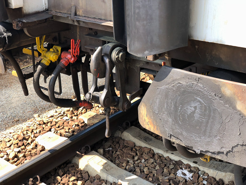 On this car the loop that would connect to another car's hook is hanging from its own hook, to keep from dragging over the ties when disconnected.