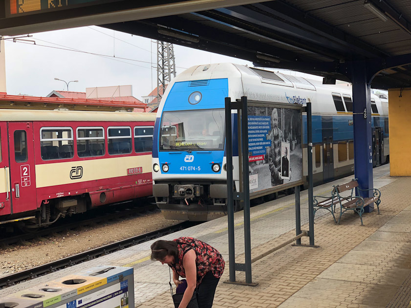 A blue double-deck commuter train next to an older red long distance train.