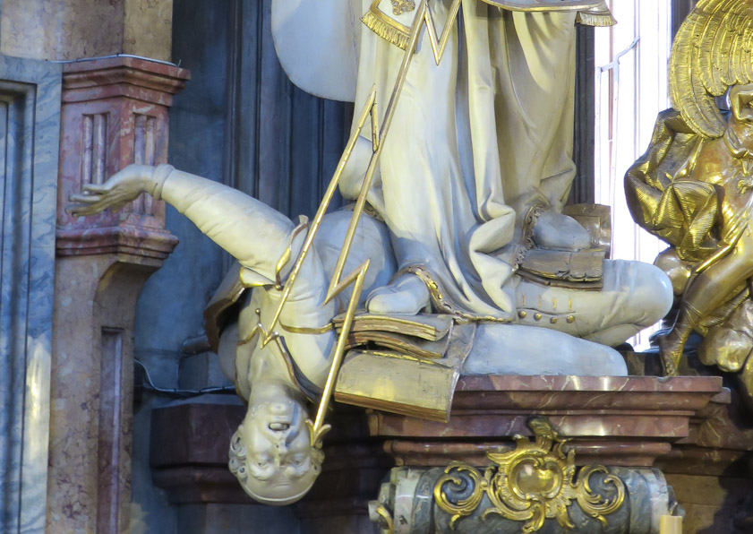 This closeup shows St. Ignatius treading on heretical books while the heretic is being zapped. The Jesuits were brought in to mop up the heretical Hussites.