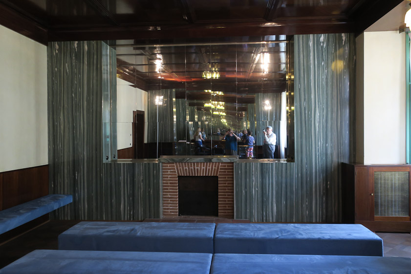 This faces the other mirror. What used to be a living room seems now to be outfitted as a small lecture room.