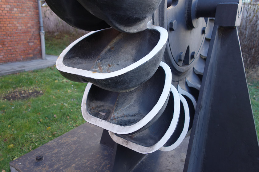 Thejet of water striking each bucket of the Pelton wheel was diverted right and left by a septurm in the middle, just visible here.