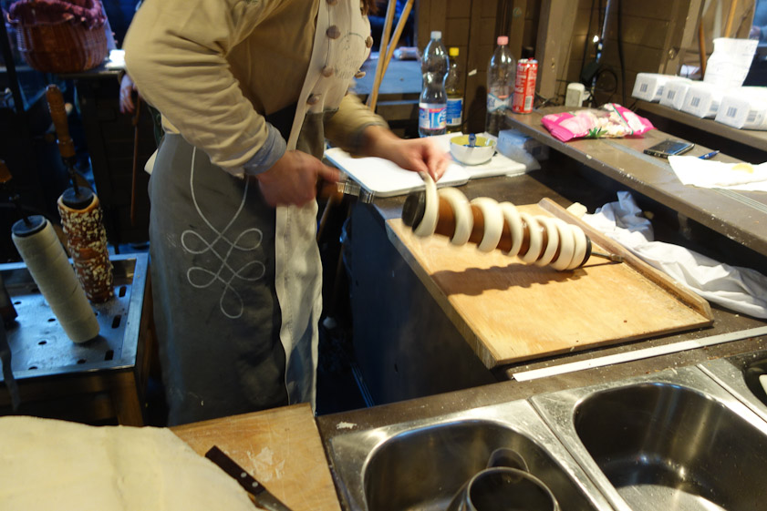 Cake dough is formed by hand into long ribbons which are wound around a cylindrical form.