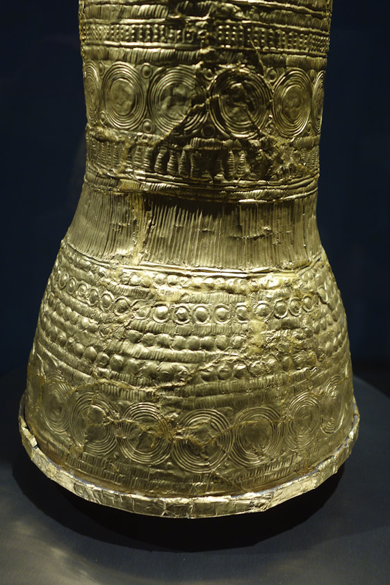 The material is gold foil, strengthened at the bottom by a bronze ring, to which a brim, now missing, was attached.