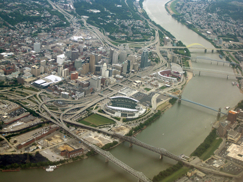 Mill Creek is out of sight to the left. This is downtown Cincinnati, with the baseball station above and to the right and the football stadium to the left and closer to us. The SIA convention hotel, the Hilton, is the light colored tall building with the pyramid on top directly above the left side of the football stadium. The Roebling Bridge is the narrow blue line between the two stadiums connecting Kentucky to Ohio.