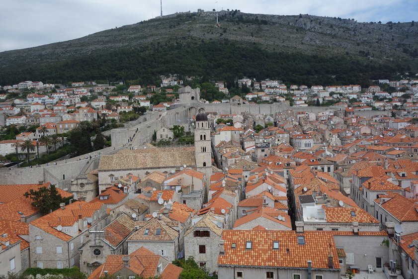A view to the north of the hills on the mainland occupied by Serbian and Montenegran forces during the 1991-92 seige. The tower in the cnter is the Franciscan church and monastery. People can be seen walking on top of the walls of Dubrovnik at the left.