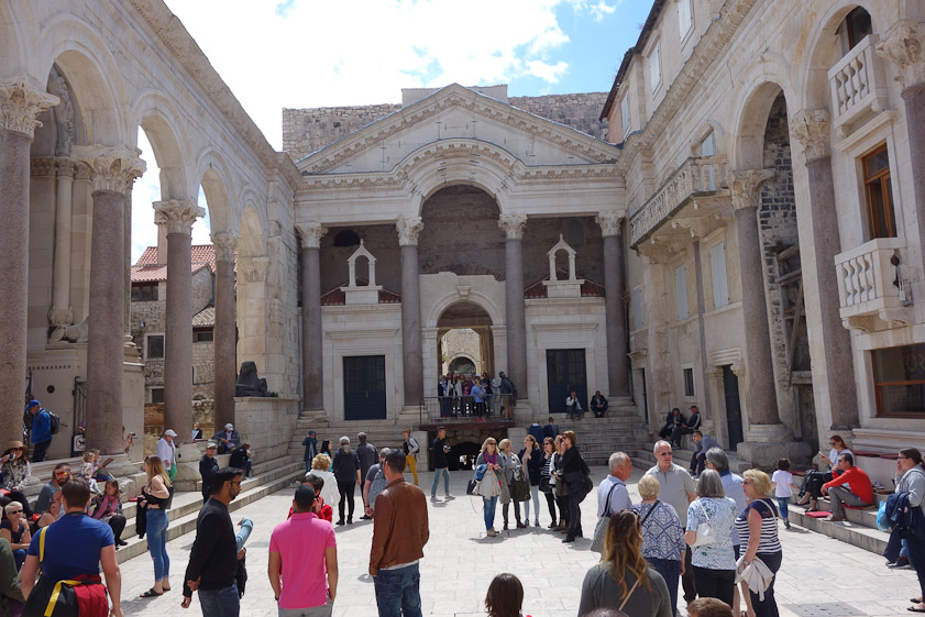 The Peristyle is a square at the middle of the palace. On the left (east) is a colonnade, beyond which was Diocletian's Mausoleum, now the Cathedral. On the right (west) was another colonnade, now absorbed and obscured by medieval palaces which incorporate them. Straight ahead (south) is a portico leading to the Vestibule, the entrance to Diocleatian's private quarters.