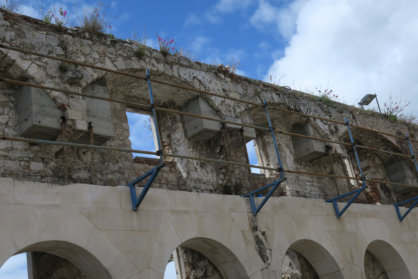 The south wall of the palace, looking south.Note the modern concrete blocks at the ends of the arches and the nwe stone wall of arches below those supporting the original wall.
