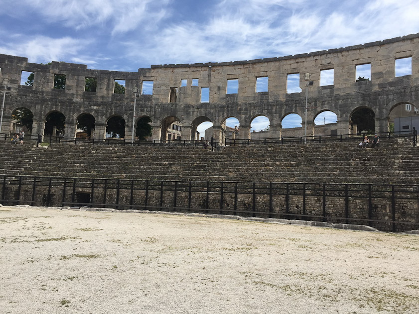 The arena was built on a sloping hillock, and seats remain on the eastern, uphill side. They are used for an outdoor film festival.