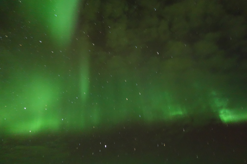 Two and half minutes later the aurora is clearly shining through thin clouds. This was a 6 second exposure, f/1.8, ISO 3200.