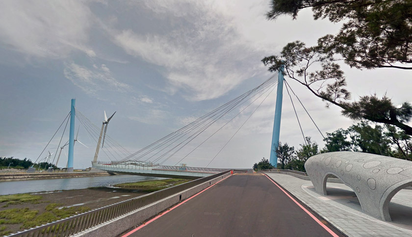 This Google Street View image was taken in July 2016 from the eastern approach road. That is a bus shelter on the right. It is the Gao Mei Wetland Hyperbolic Landscape Bridge. 24.3036N, 120.546E