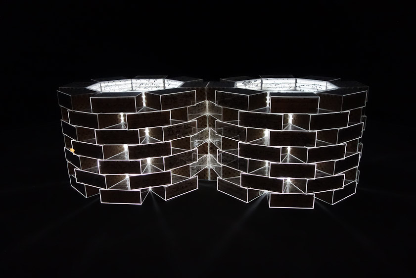 Two cylindrical stacks of Plexiglas boxes holding rolls of calligraphy.