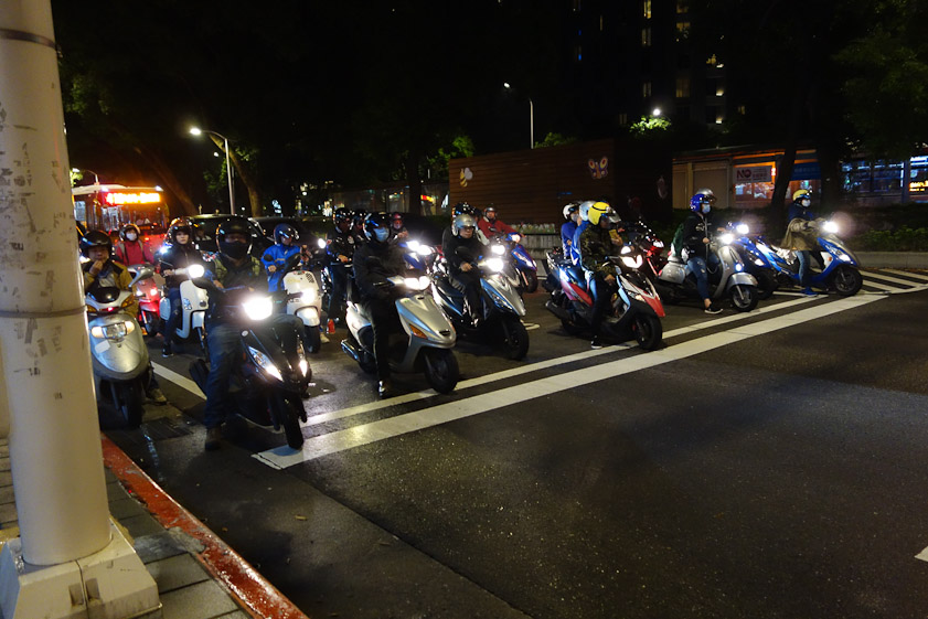 Motor scooters proliferate in Taiwan. They are given a head start ahead of 4-wheeled vehicles at stop lights. Their stop line is several feet ahead of the stop line for cars.