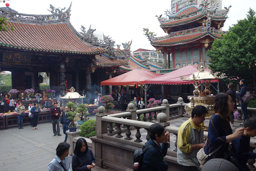 Worshipers climb a short staircase to get to the platform in front of the entrance to the main hall.