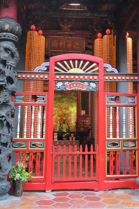 These lighted orange cylinders with hundreds of small effigies are a feature of most temples we saw.