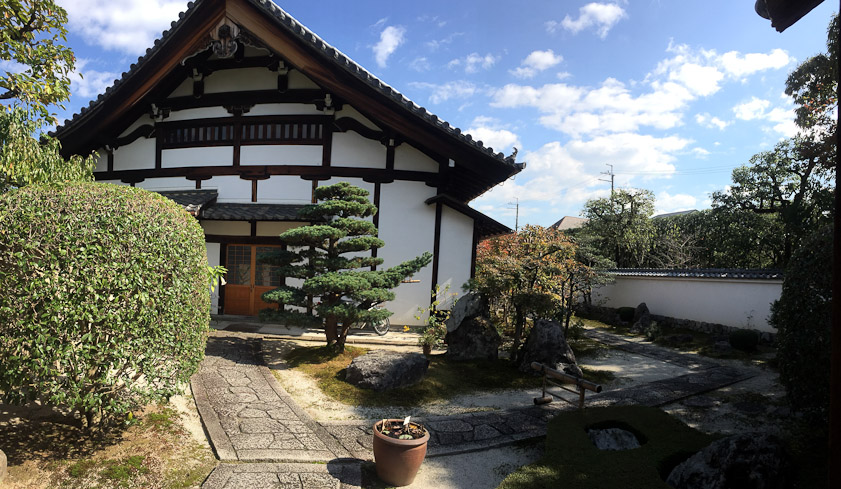 The building (dwelling) with the hedge-rock feature.