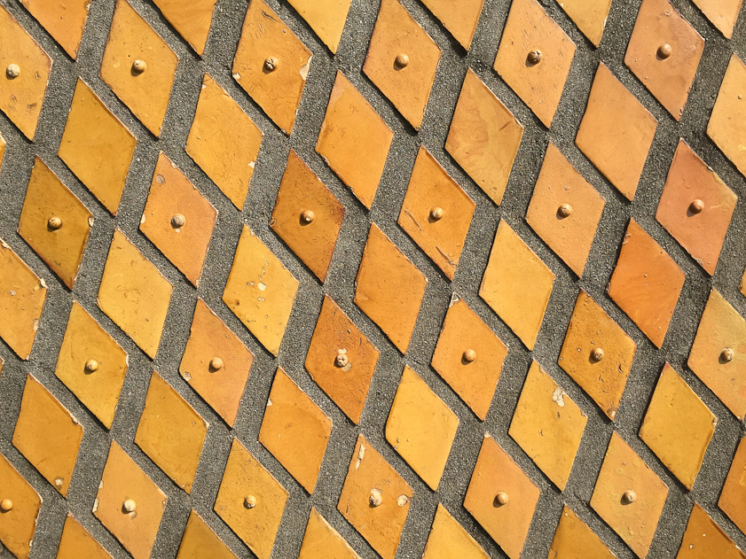 Diamond shaped tiles set in concrete form the surface of the walls.