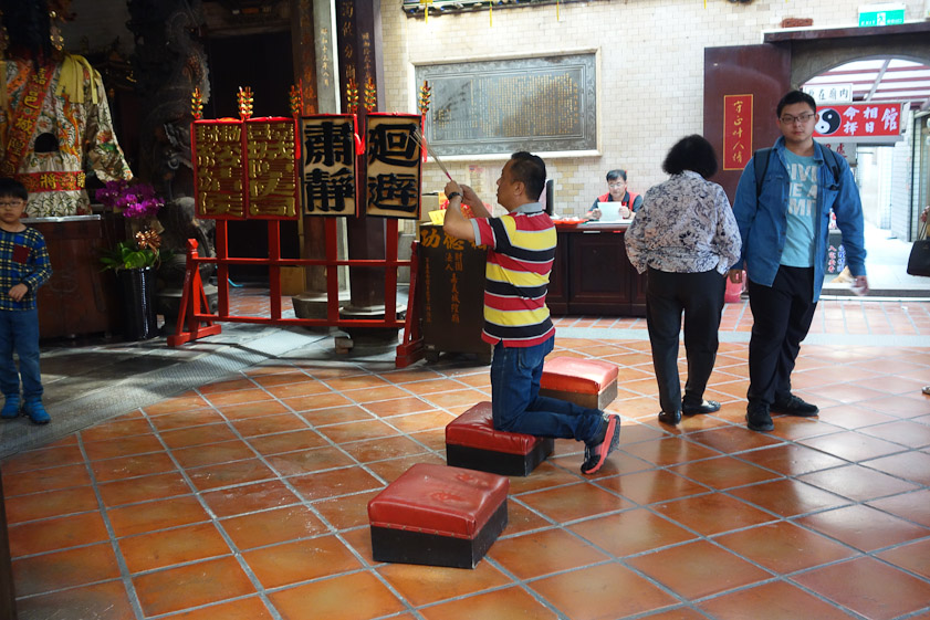 He's praying while holding up sticks of burning incense.
