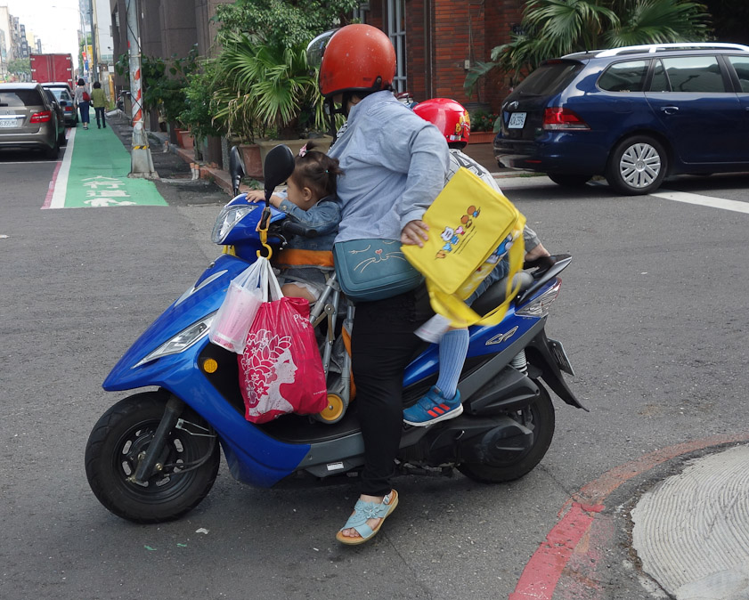The son got on the back of the seat, and purchases hung off the handlebars.