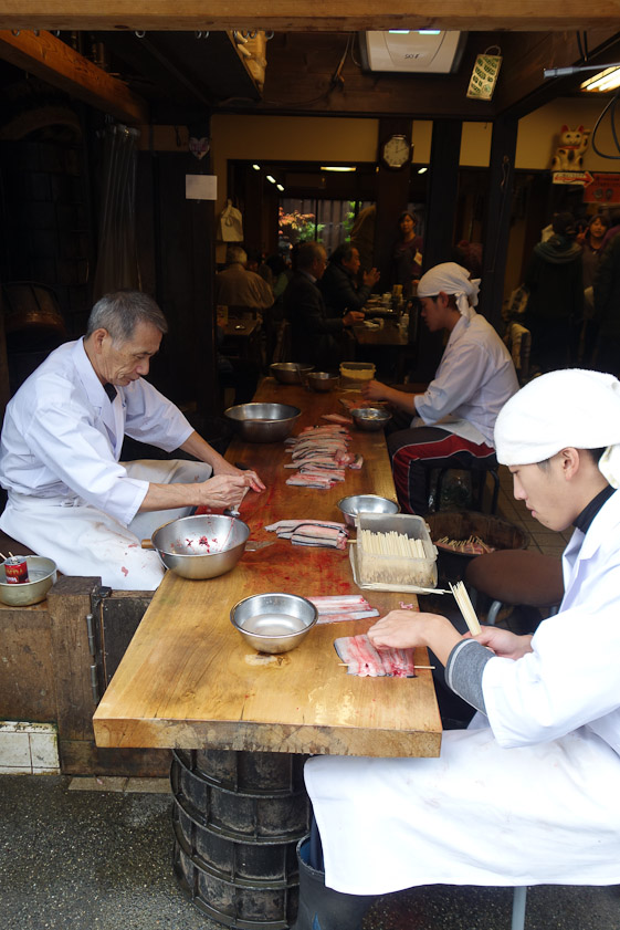 These men were preparing fish skewers for grilling.