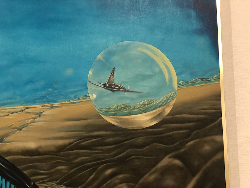 The mirror image of the crystal ball appears elsewhere in the painting.