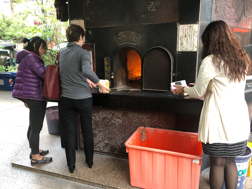 These ladies are burnign joss money for their ancestors' upkeep in the afterlife.