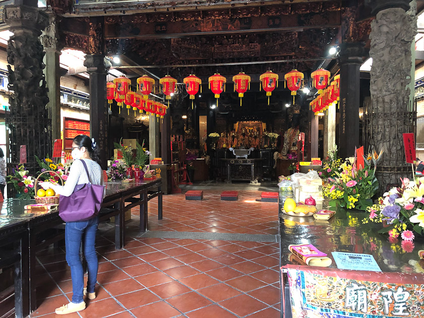Rhe altar is straight ahead, with kneeling pads, and offerings are on the tables on either side