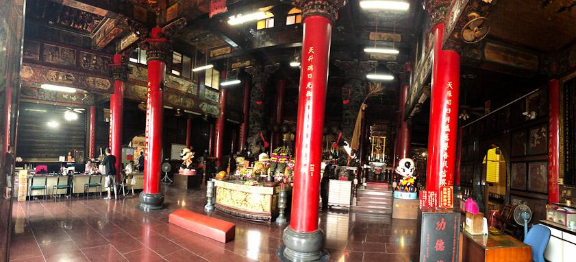 The first, large room of a temple has a low red kneeling pad.