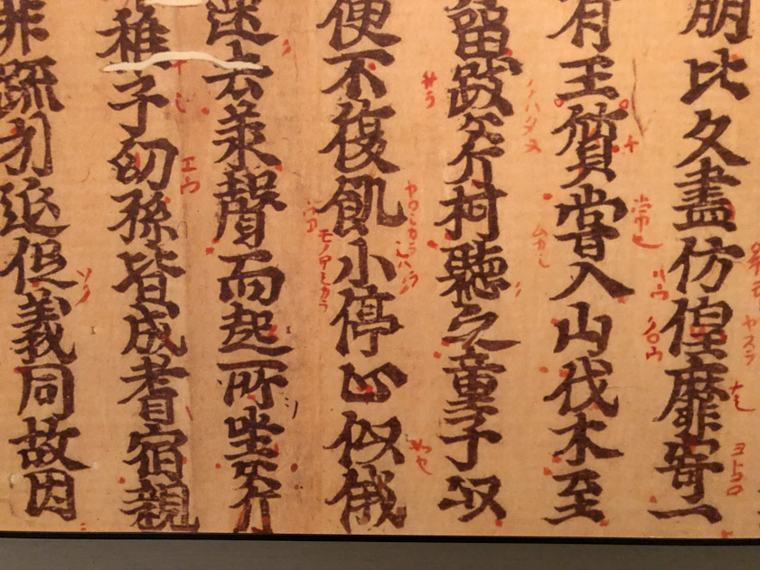 The Japanese developed syllabaries, that is sumbols for sounds. They are written in red next to the large black Chinese charaters. The museum label called these 