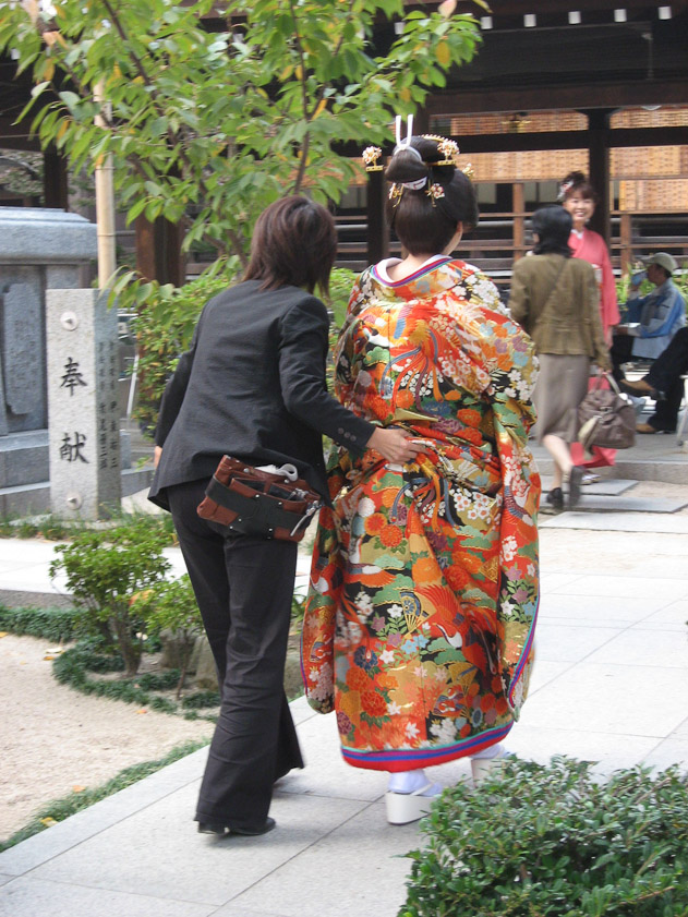 The bride being moved into position by the photographer's assistant.