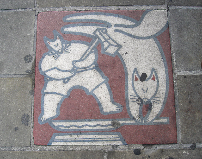 Tile in the street in Nagasaki. I think these two cats are forging a sword, but I haven't discovered more.