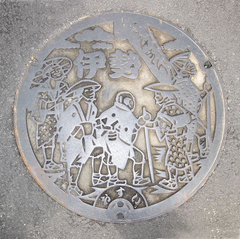 Manhole cover in Ise showing pilgrims coming to the Ise shrines.