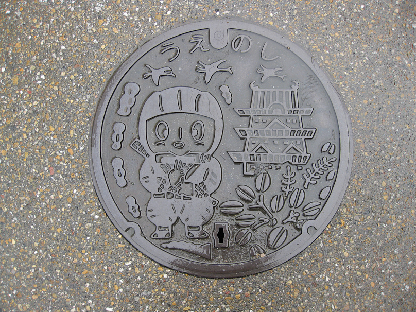 Manhole cover in Ueno, with a ninja on the left and Ueno Castle on the right. The kana at the top read uenoshi (Ueno City).