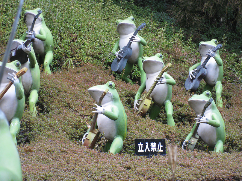 Each frog is about 4 feet tall. The sign in front says Stay Off or Do Not Enter.