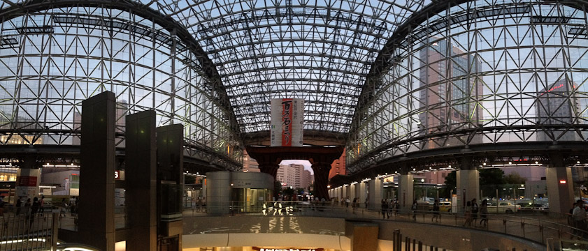 Kanazawa Station has a large glass-covered area and a huge wooden gate at the entrance.