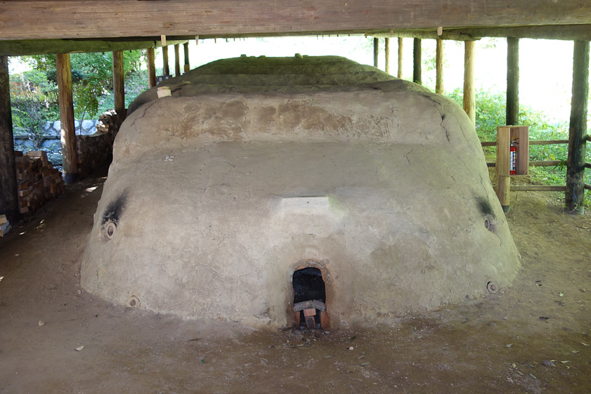 The firebox at the base of the climbing kiln has a surprisingly small opening. The small holes right and left are for stoking with small pieces of wood, and there are other stoke holes in the chambers uphill. There appear to be six chambers.