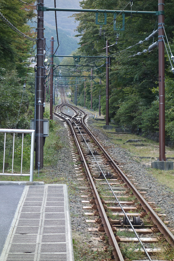 The cable runs on pulleys set between the tracks. The Y in the tracks allows descending and ascending cars to pass and otherwise share the same set of tracks.