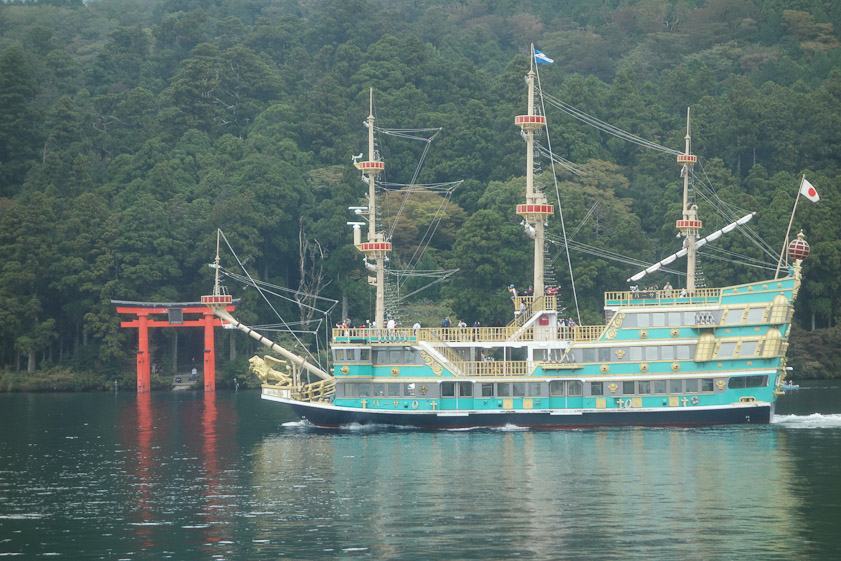 Another fanciful cruise ship passing in front of the torii at the end of a long, straight path leading uphill to Hakone shrine.