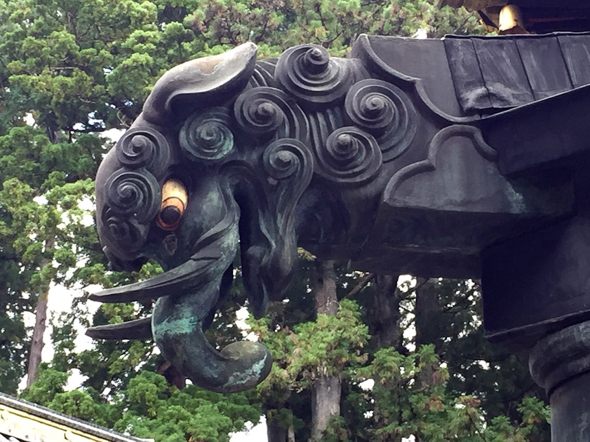 Angry elephant at the corner of the roof over a lantern.