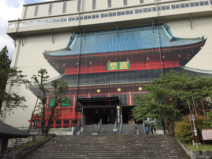 Downhill from the Toshogu is Rinnoji, a temple founded in 766, more than a millenium before the Toshogu. The Sanbutsudo at Rinnoji is undergoing restoration inside this immense temporary building, with a photo of the old building printed on its side.