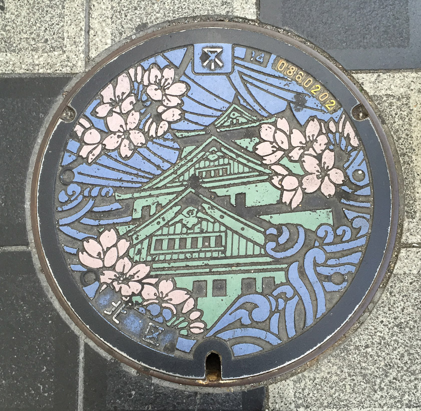 Manhole cover in Osaka, showing the Osaka Castle.