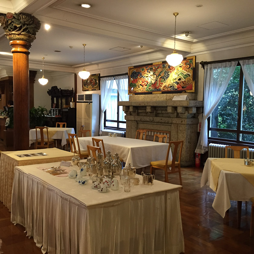 The Kanaya dining room features many intricate wood carvings. The stone of the fireplace is called Oya-ishi (Oya stone), volcanic tuff with many voids used in many buildings in Tochigi prefecture.