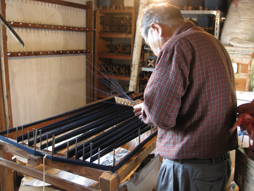 In the room over the dye vats Mariana saw people weaving. I'd like to know what this man was doing. Many filaments appear to be leading from a tool in his hand to the wall.