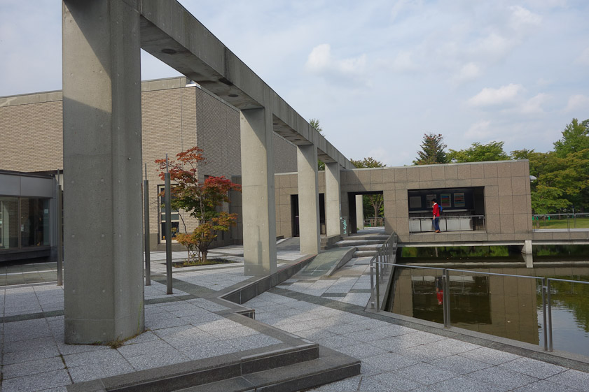 The lady in red is walking toward the entrance to the Sapporo Art Museum.