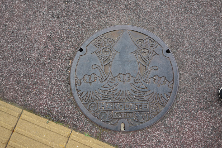 Manhole cover in Hakodate. Three squids. The kana read OSUI or sewage.